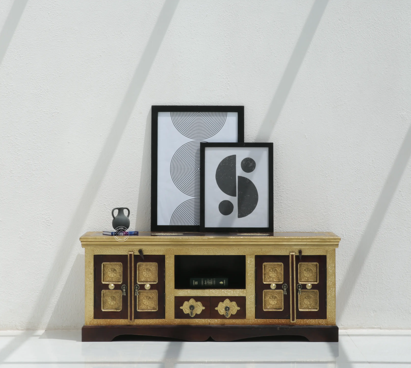 Wooden entertainment console with decorative items against a white wall