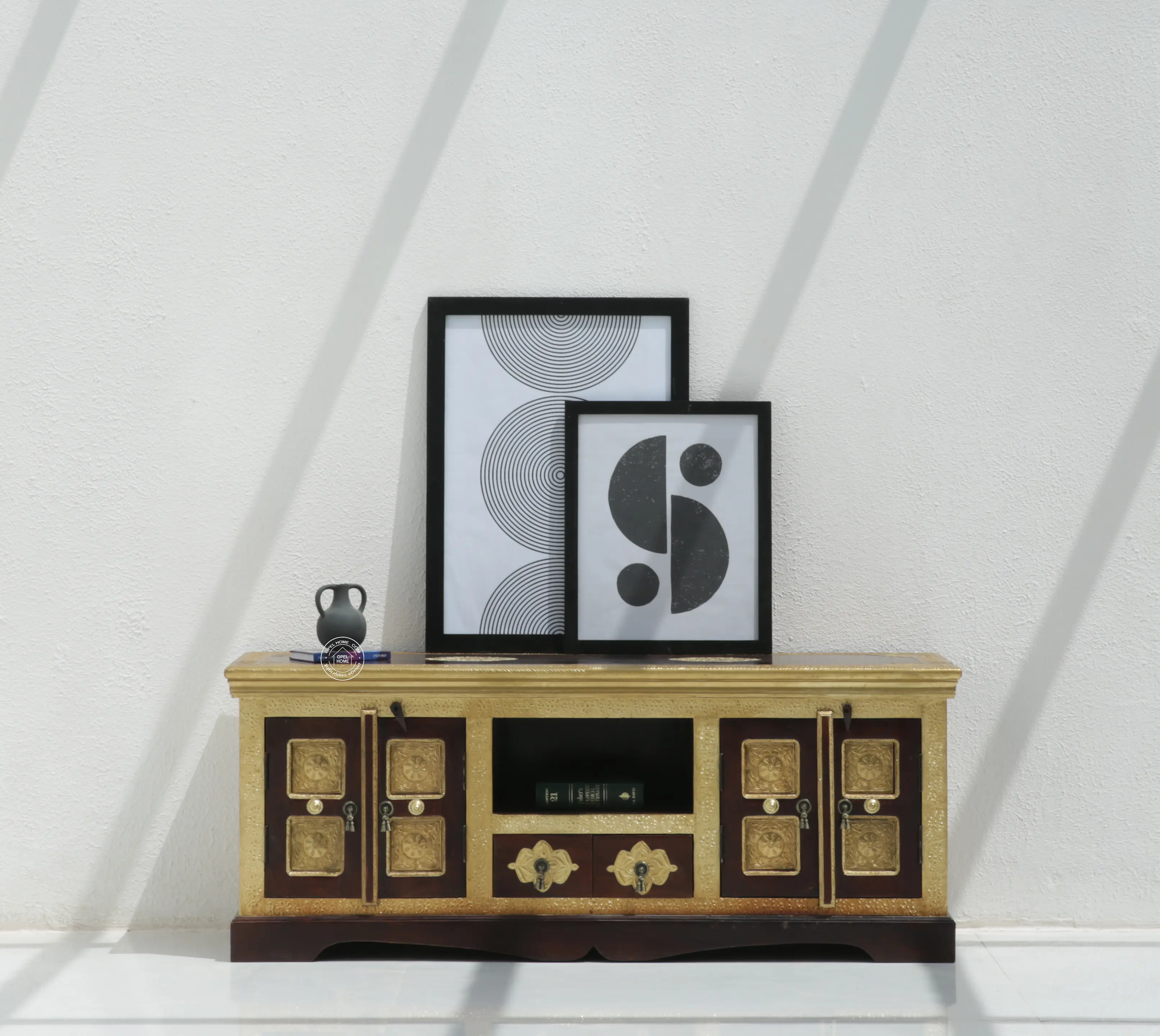Wooden entertainment console with decorative items against a white wall